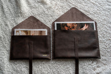 Leather print envelopes holding deckled edge prints.